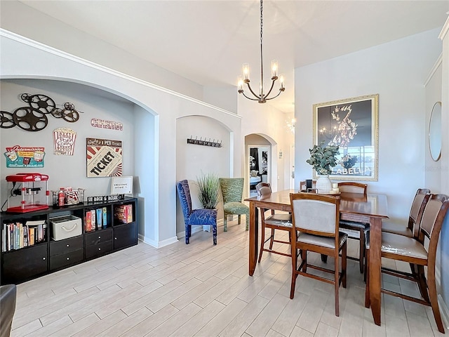 dining room with light wood-type flooring and an inviting chandelier