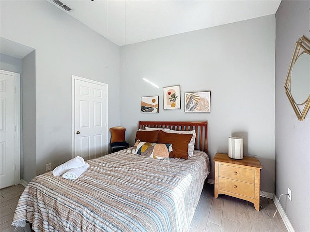 bedroom with wood-type flooring and lofted ceiling