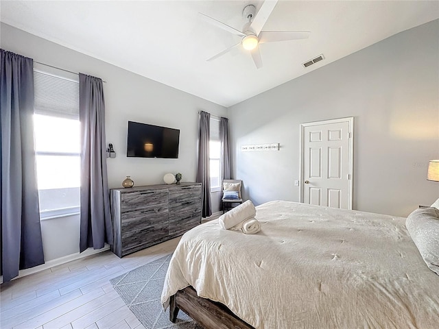 bedroom with ceiling fan, lofted ceiling, and multiple windows