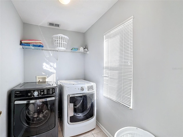 washroom with light tile patterned floors and separate washer and dryer