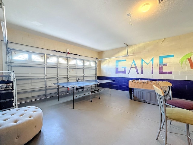 playroom featuring a textured ceiling and concrete floors