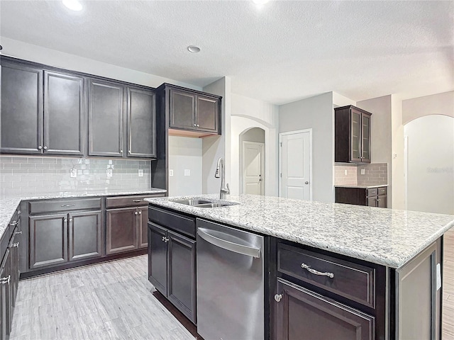 kitchen with dishwasher, light hardwood / wood-style floors, decorative backsplash, a kitchen island, and sink