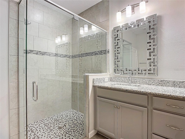 bathroom with walk in shower and vanity