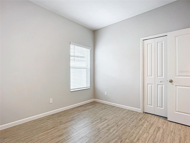 unfurnished bedroom with a closet and light wood-type flooring