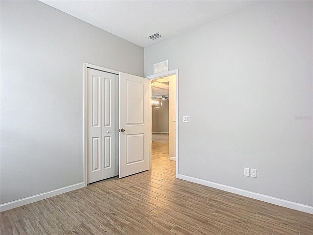 unfurnished bedroom with a closet and hardwood / wood-style flooring