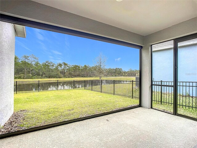 unfurnished sunroom featuring a water view