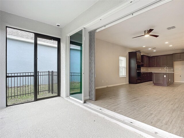 unfurnished living room featuring ceiling fan, a wealth of natural light, and sink