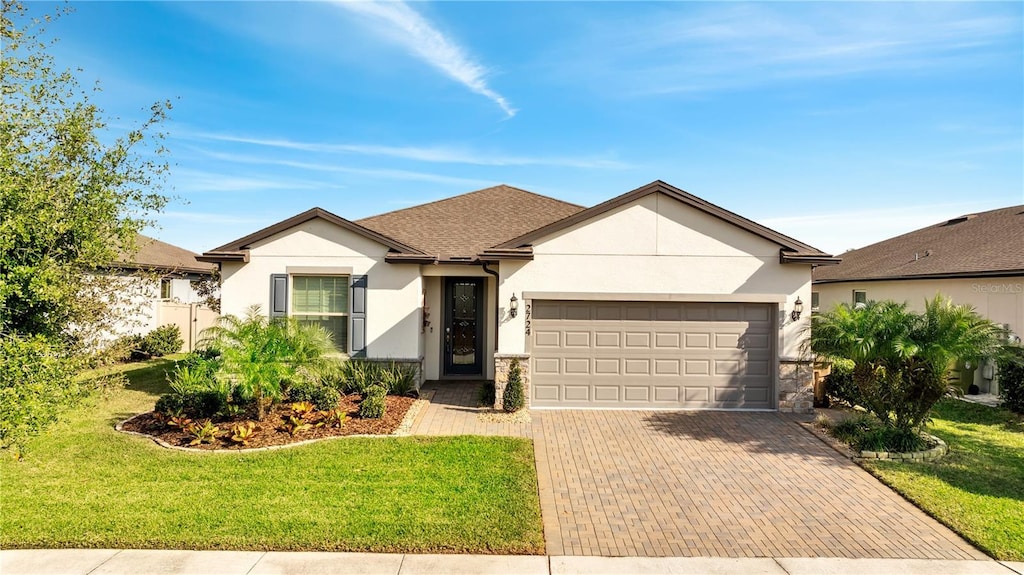 ranch-style home with a garage and a front lawn