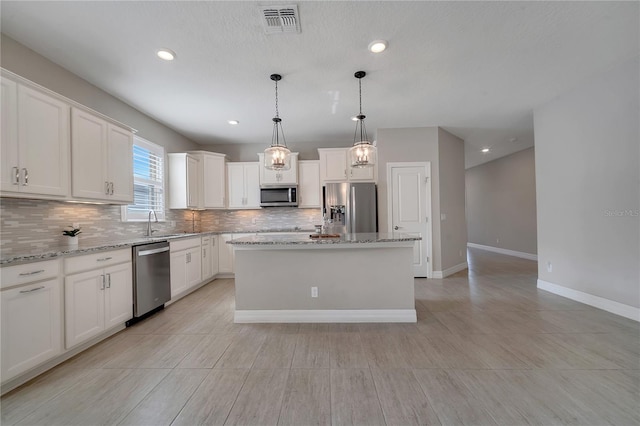 kitchen featuring white cabinets, a center island, and stainless steel appliances