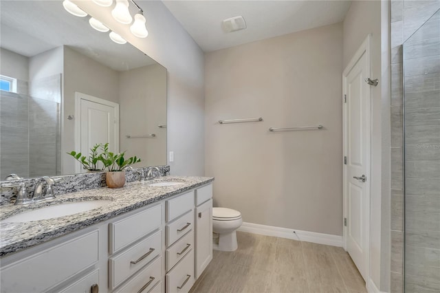 bathroom featuring toilet, walk in shower, and vanity