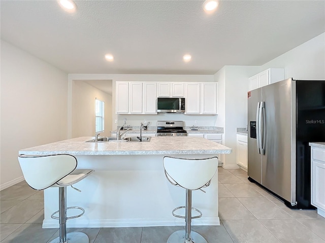 kitchen with white cabinetry, an island with sink, and stainless steel appliances