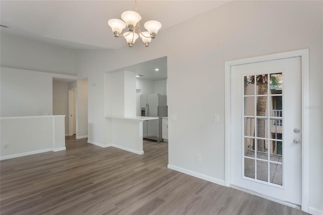 unfurnished dining area with a chandelier and hardwood / wood-style flooring