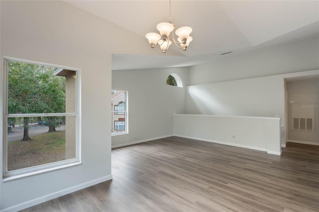 interior space with a chandelier, lofted ceiling, and hardwood / wood-style flooring