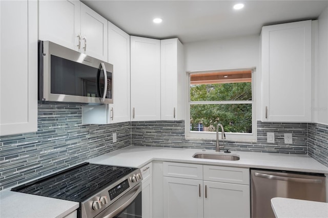 kitchen with decorative backsplash, appliances with stainless steel finishes, white cabinetry, and sink