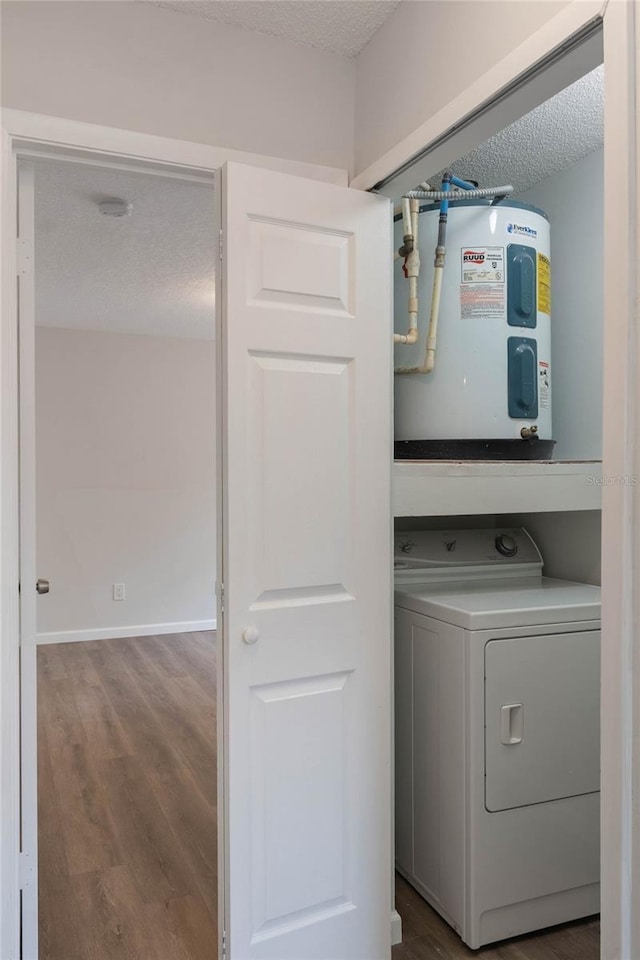 laundry room featuring washer / dryer, electric water heater, a textured ceiling, and wood-type flooring