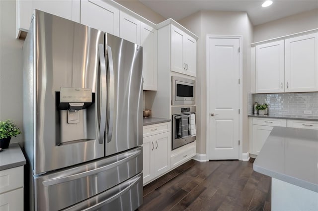 kitchen featuring dark hardwood / wood-style floors, white cabinetry, backsplash, and appliances with stainless steel finishes