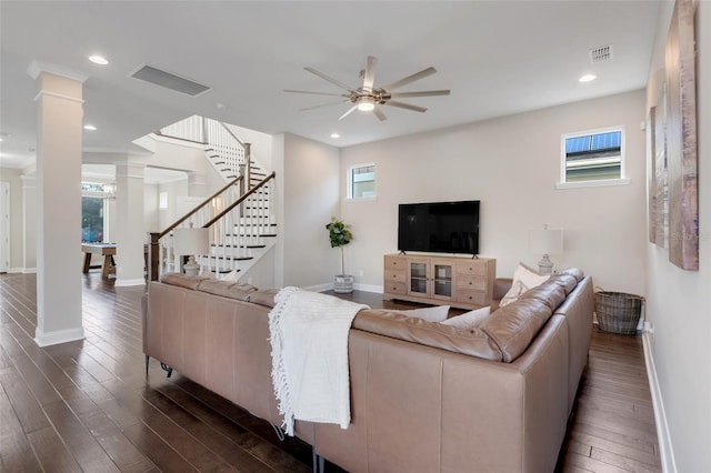 living room featuring dark hardwood / wood-style floors, a healthy amount of sunlight, and decorative columns