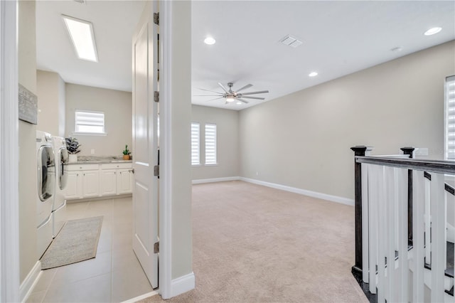 hallway with a wealth of natural light, washer and dryer, and light carpet