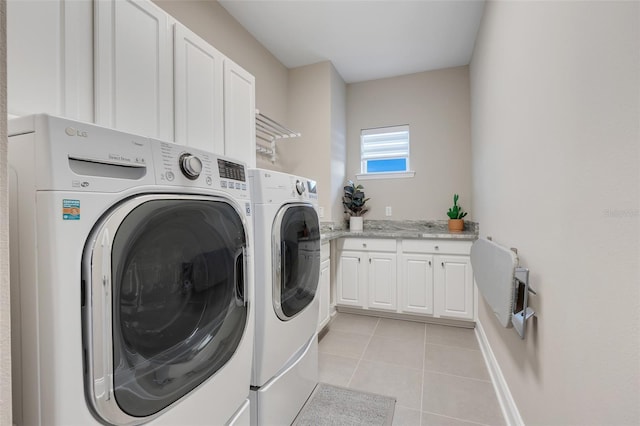 clothes washing area with cabinets, independent washer and dryer, and light tile patterned floors