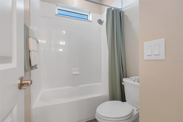 bathroom featuring shower / tub combo and toilet