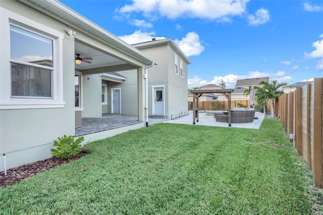 view of yard featuring outdoor lounge area, ceiling fan, and a patio