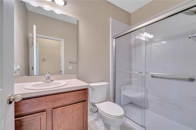 bathroom with vanity, toilet, a shower with shower door, and a notable chandelier