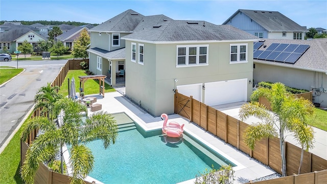 rear view of house featuring a fenced in pool and a garage