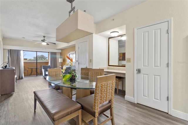 dining space with light hardwood / wood-style floors and ceiling fan