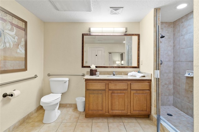 bathroom with vanity, tile patterned floors, toilet, a textured ceiling, and walk in shower