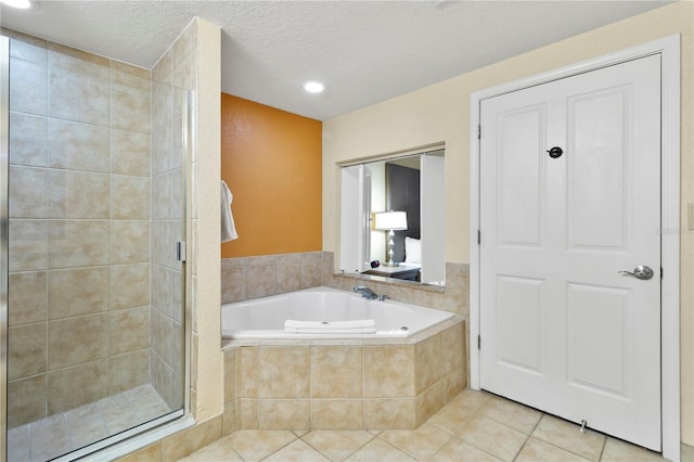 bathroom featuring plus walk in shower, a textured ceiling, and tile patterned floors