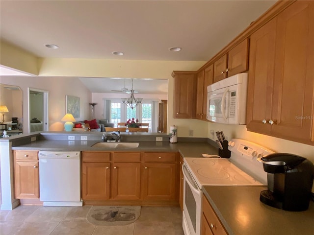 kitchen featuring sink, light tile patterned floors, white appliances, and an inviting chandelier