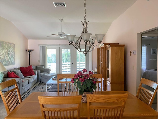 tiled dining room with ceiling fan with notable chandelier, french doors, and vaulted ceiling