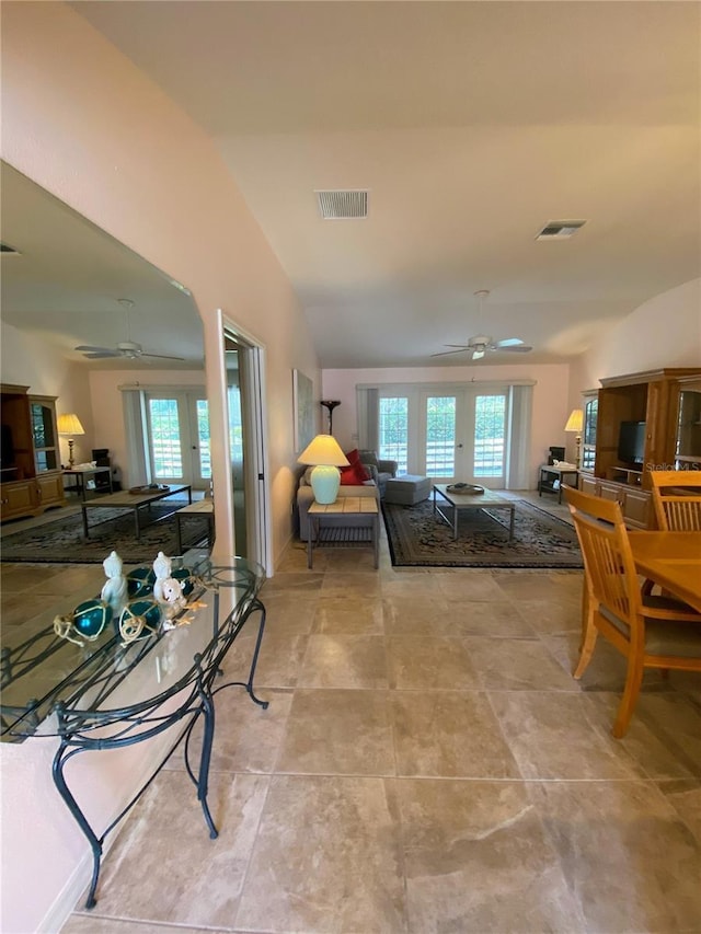 living room with ceiling fan, vaulted ceiling, and french doors