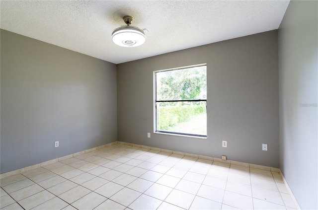 empty room featuring light tile patterned flooring and a textured ceiling