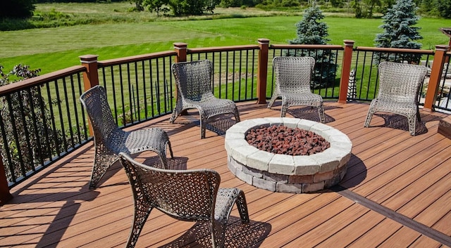 wooden deck with a yard and a fire pit