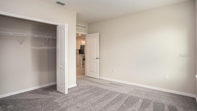 unfurnished bedroom with a closet and carpet floors