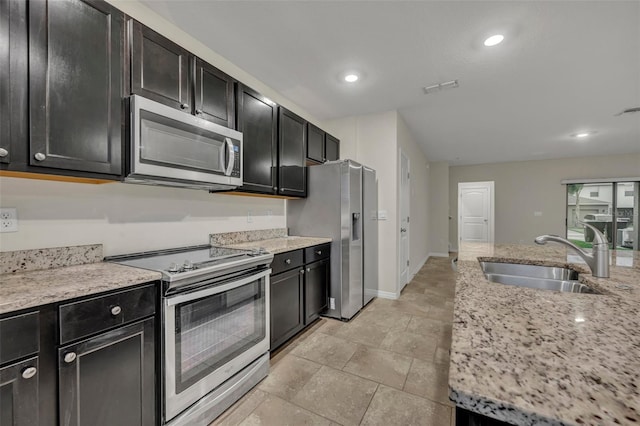 kitchen featuring light stone counters, sink, and stainless steel appliances