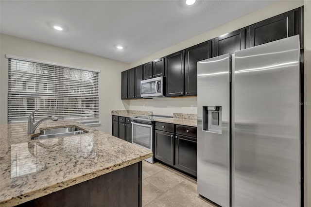 kitchen with sink, light stone countertops, and stainless steel appliances