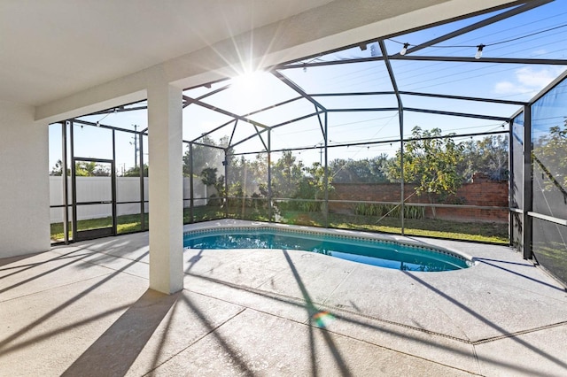 view of pool featuring glass enclosure and a patio