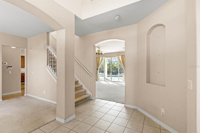 carpeted foyer featuring a textured ceiling and ceiling fan