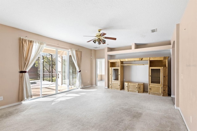 unfurnished living room featuring a textured ceiling, light colored carpet, and ceiling fan