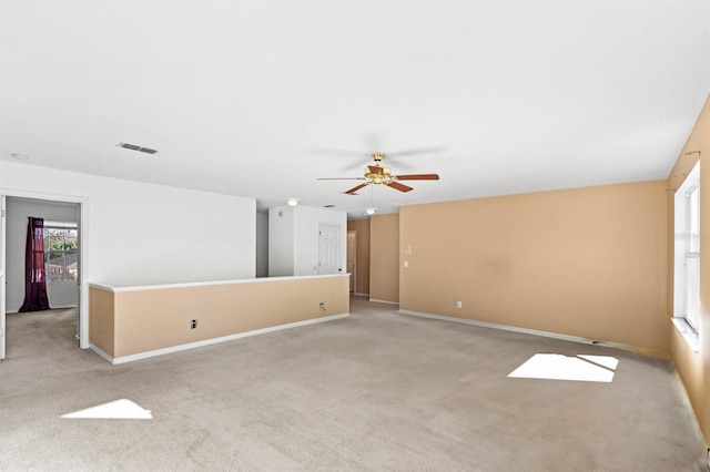 unfurnished living room featuring ceiling fan and light colored carpet