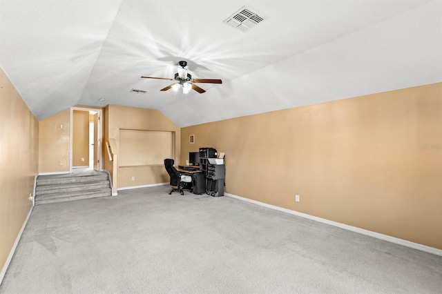 unfurnished office featuring ceiling fan, light colored carpet, and lofted ceiling