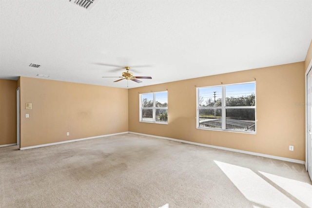 unfurnished room with ceiling fan, light colored carpet, and a textured ceiling