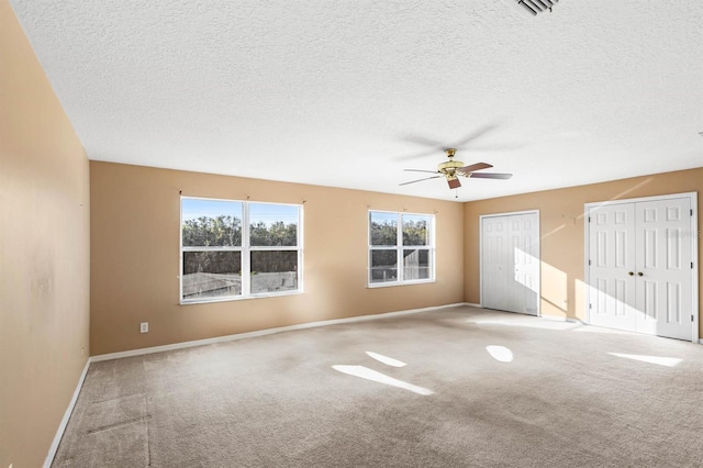 unfurnished room with a textured ceiling, light colored carpet, and ceiling fan