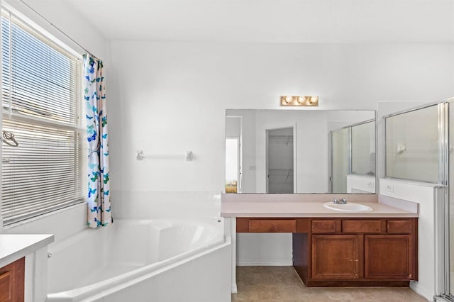 bathroom with vanity and shower with separate bathtub