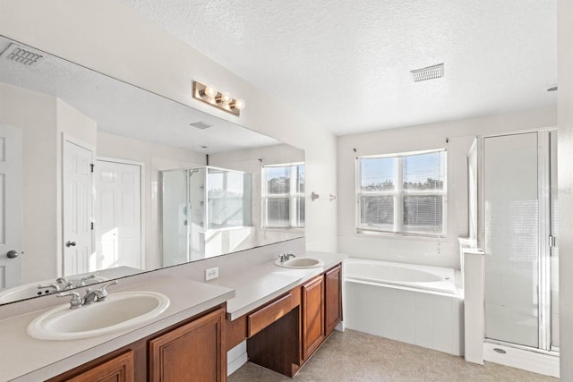 bathroom featuring a textured ceiling, vanity, and separate shower and tub