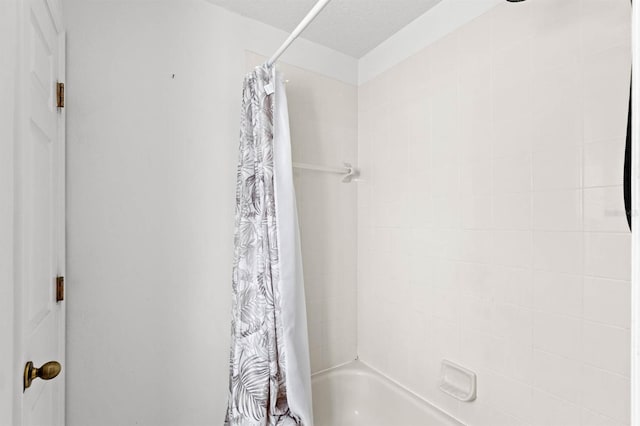 bathroom featuring shower / bath combo and a textured ceiling