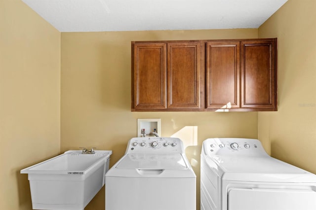 laundry room with washer and dryer, cabinets, and sink