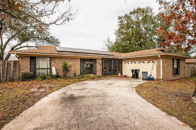 single story home featuring a garage and solar panels